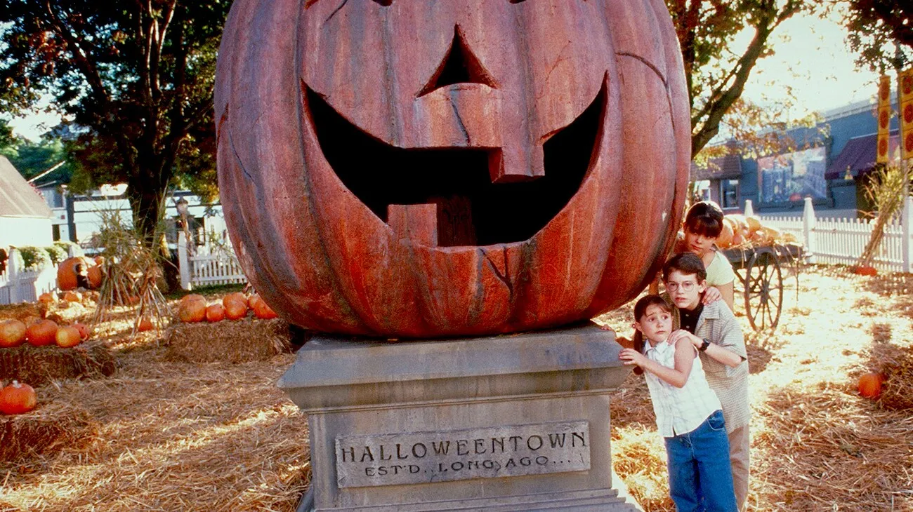 Marnie and her siblings peek from beside Halloweentown’s giant jack-o’-lantern.