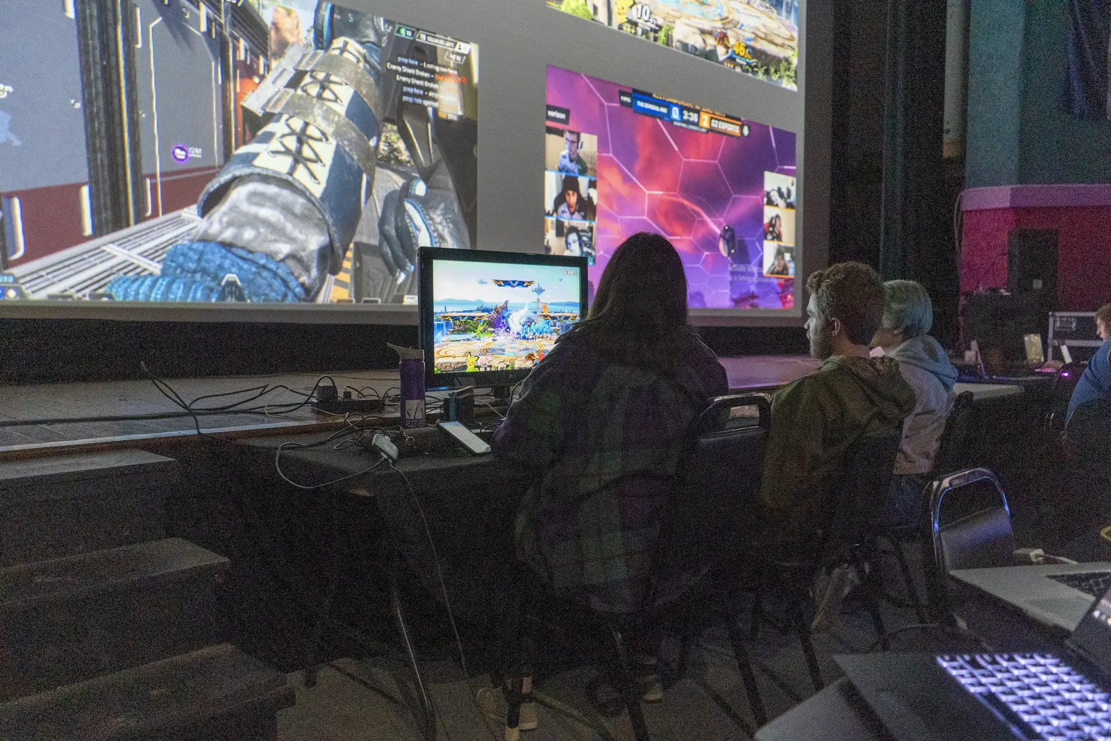 Players gaming together in the Fox Theatre with a large game projection behind them