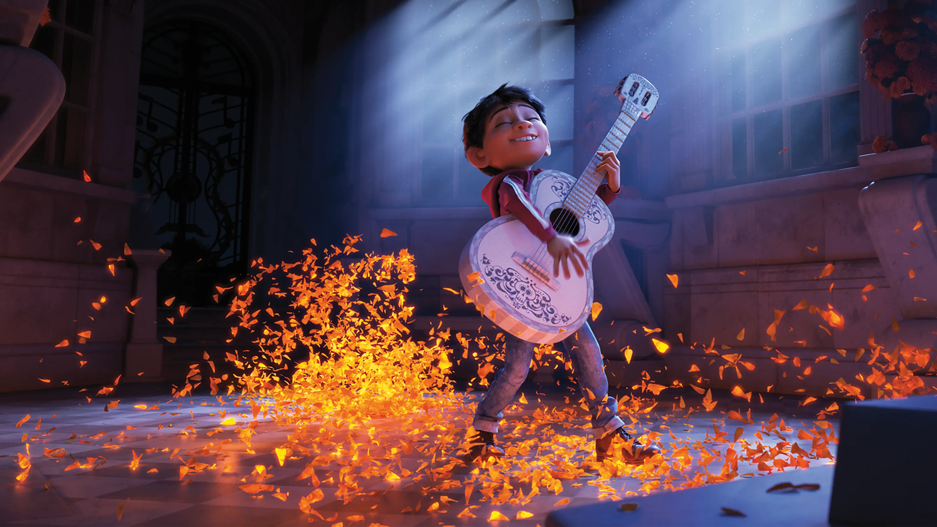 Miguel plays guitar as marigold petals glow around him in Disney/Pixar's Coco.