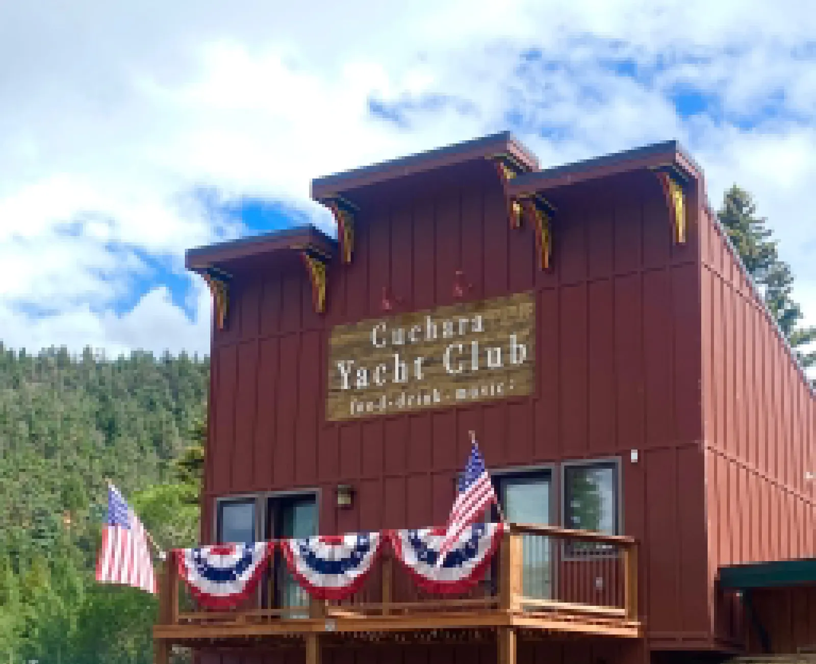 Cuchara Yacht Club building decorated with American flags and bunting.