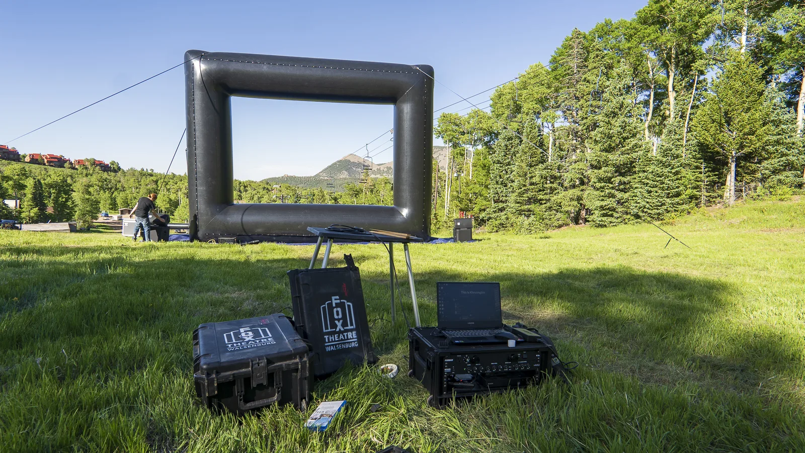 The Fox's inflatable movie screen and projection equipment set up in a mountain meadow.