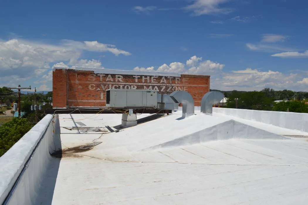 Main flat roof looking west with roofing membrane meeting the upper brick wall.