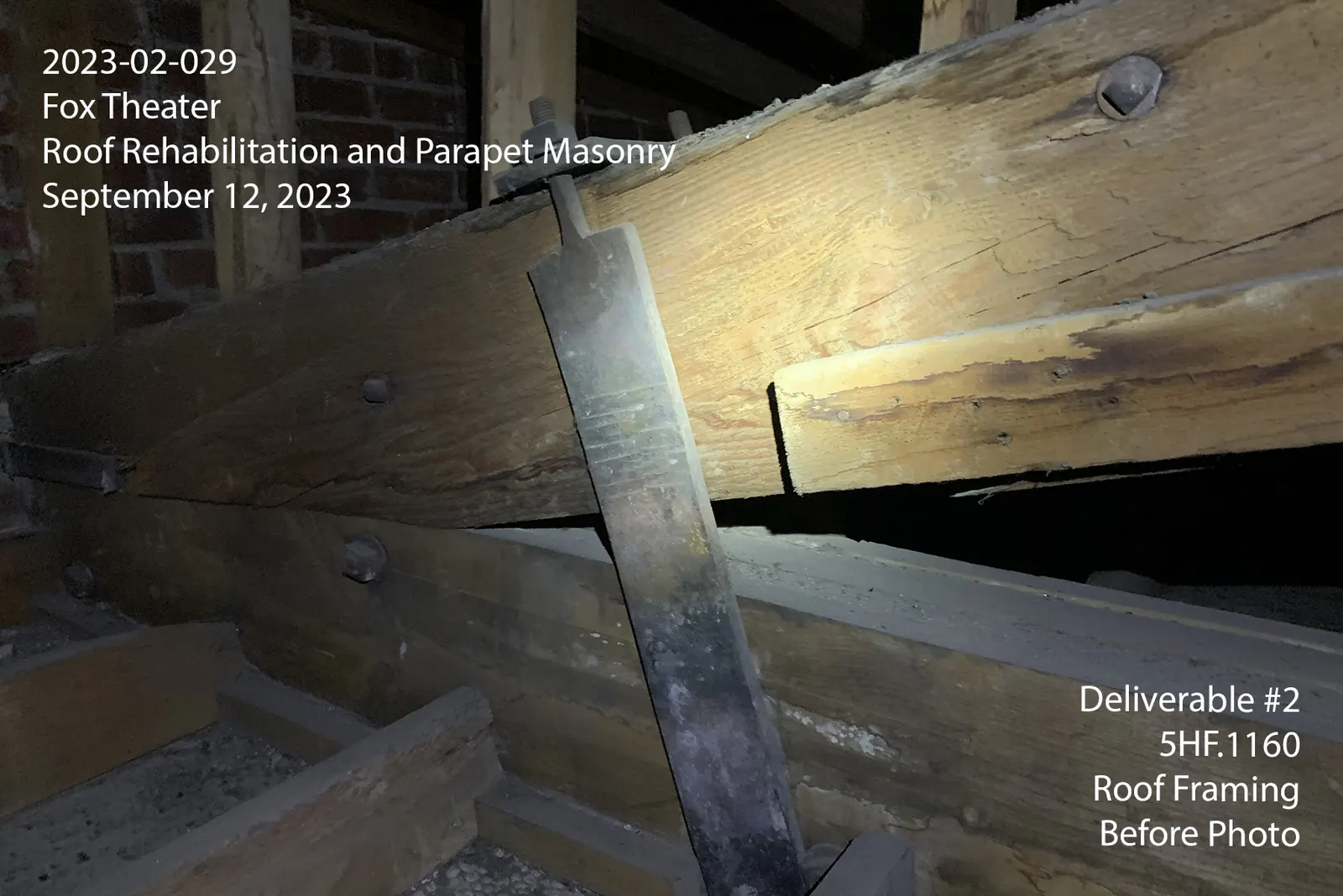 Close view of an aged timber roof beam and its metal connection before Phase 1 reinforcement.