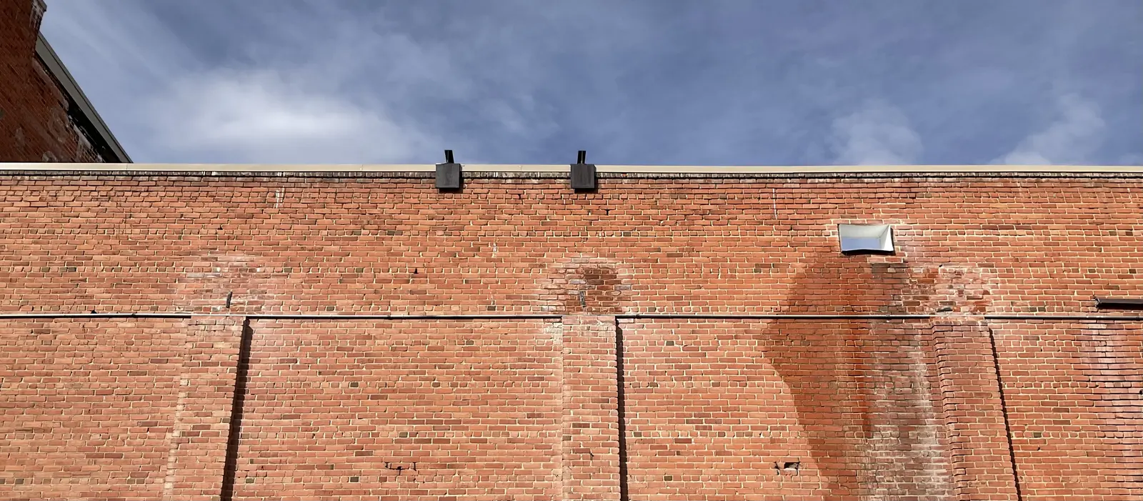 Wide view of the Fox south brick wall beneath a winter sky after masonry work.