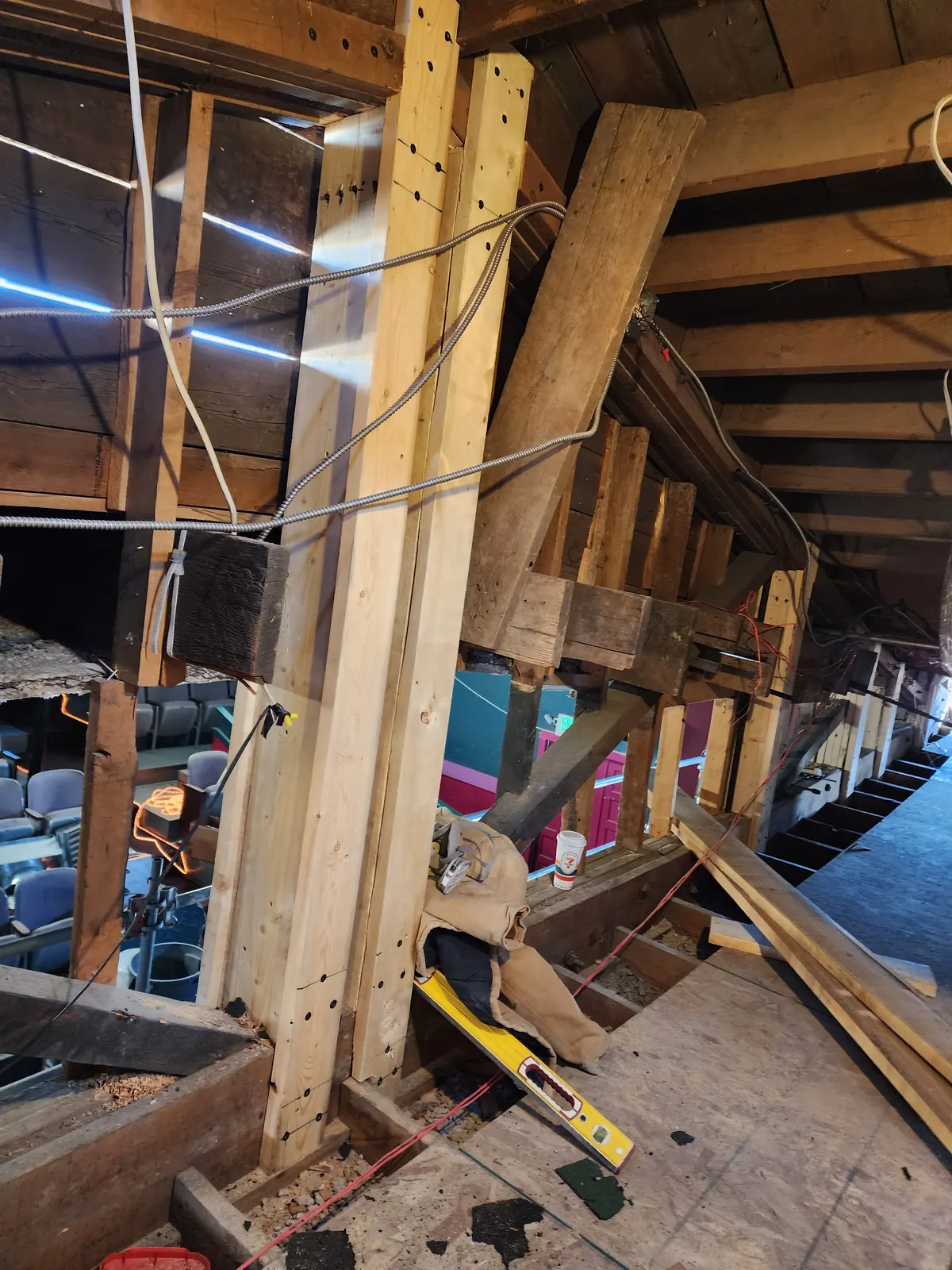 Tall temporary timber posts and bracing supporting historic roof framing inside the Fox.