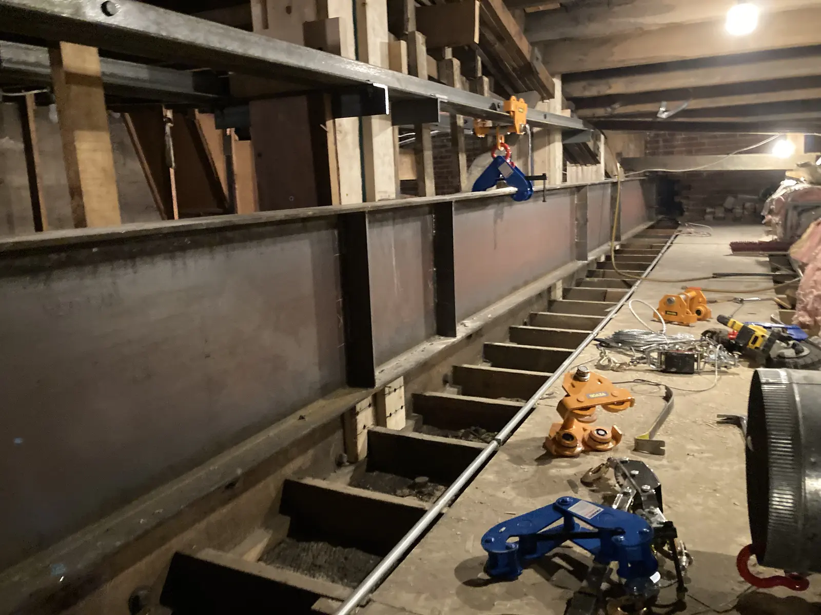 Long steel beam and new supports installed beside historic timber roof framing inside the Fox.