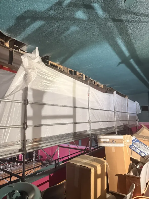 Scaffolding and protective sheeting fill part of the auditorium.