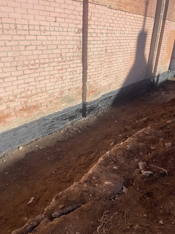 Excavation exposes the foundation below the Fox’s brick wall.