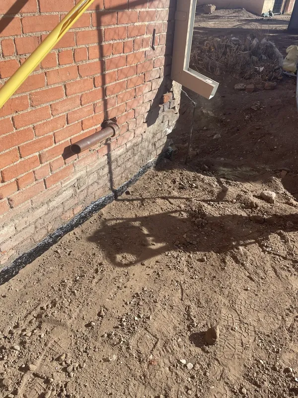The ground beside the brick wall after excavation.