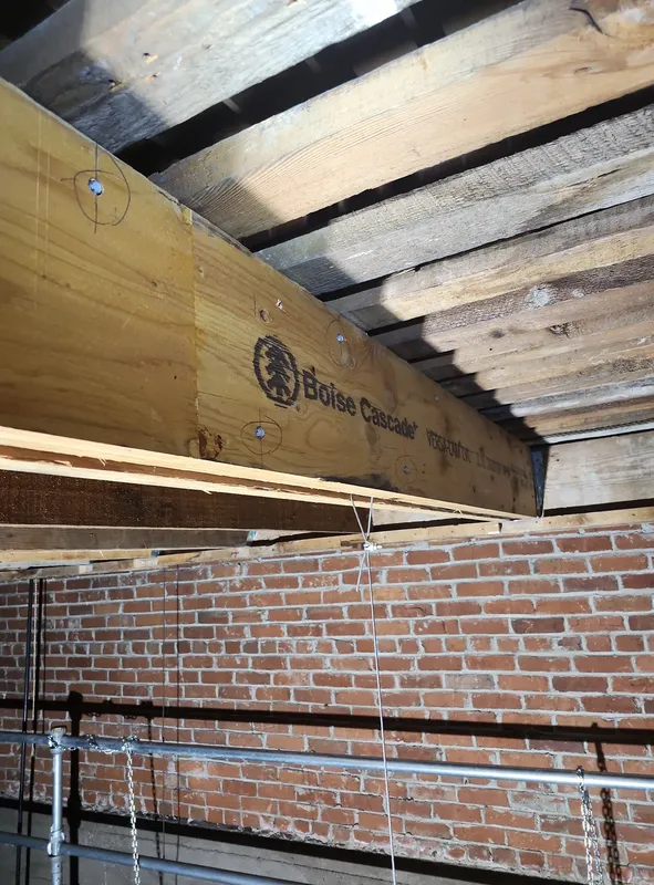 Timber reinforcement and metal connections beneath the original joists.